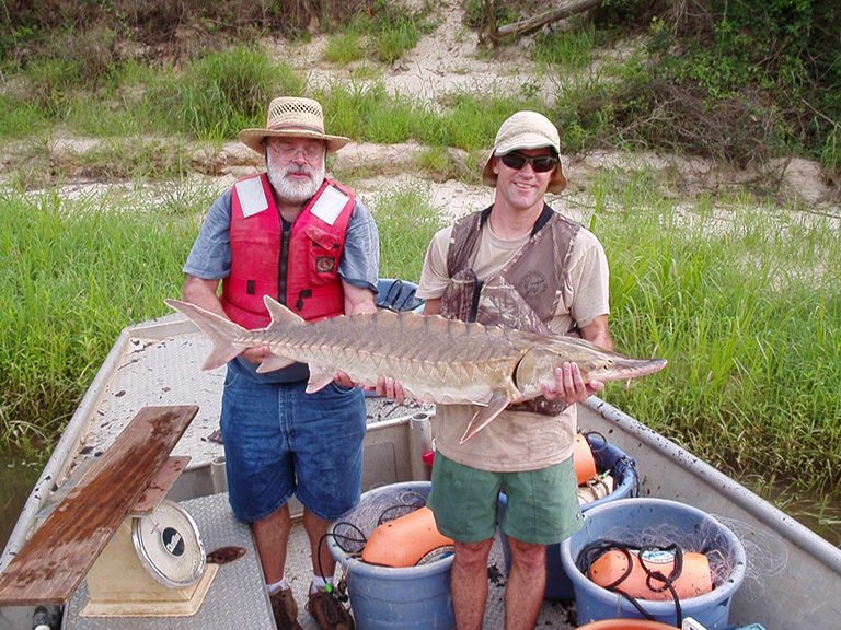 Two men holding their caught fish